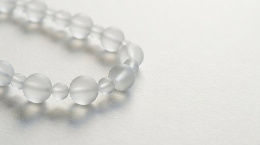 Kette aus milchglasartigen Gliedern als Sinnbild für Aminosäuren als Bausteine von Proteinen