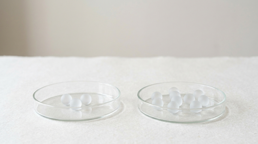 Zwei Glasschalen nebeneinander, links drei, rechts neun milchglasartige Kugeln als Sinnbild für BCAA und EAA